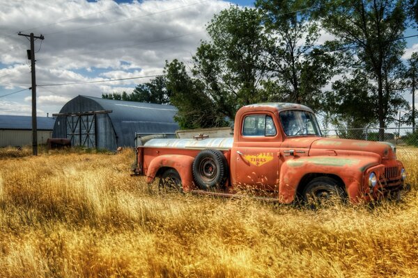 Orange truck at the hangar in the field