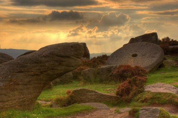 Grandes rocas en un claro verde bajo densas nubes