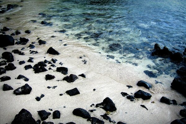 Steine im Sand am Ufer