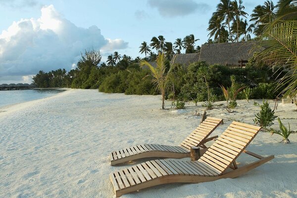 Spiaggia di sabbia con lettini in legno