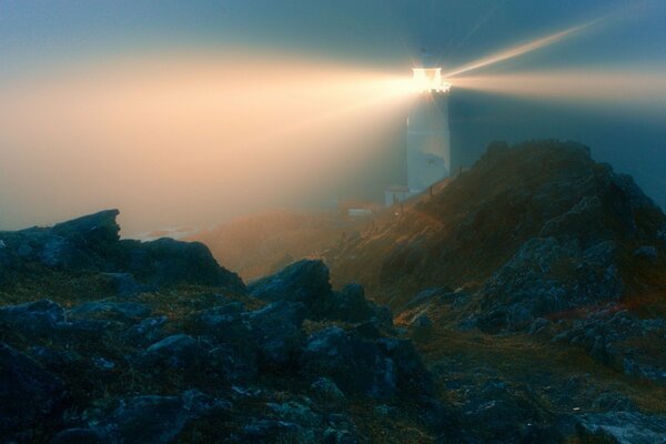 Night lighthouse through the stones