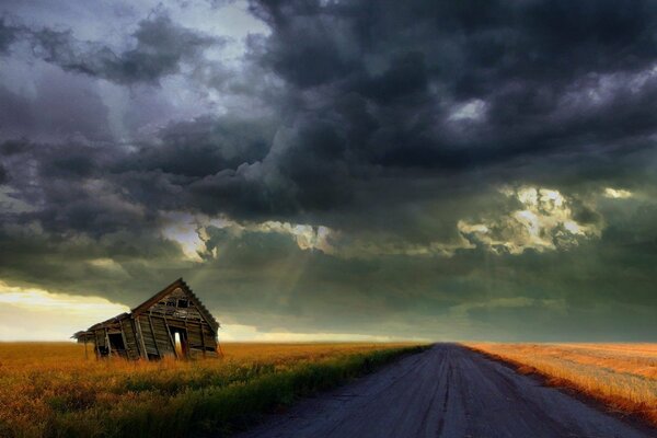 A road under a stormy sky and a shed on the side