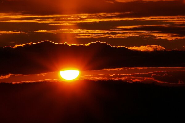 Malinowy Zachód słońca. Słońce za chmurami