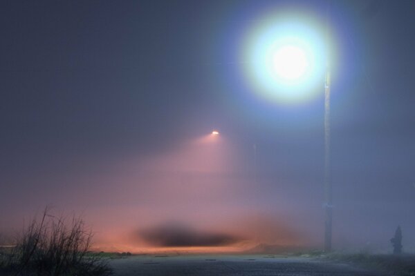 Une lanterne dans le brouillard illumine la route