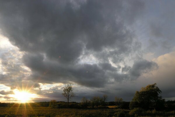 Die Sonne am Horizont schaut durch die Wolken