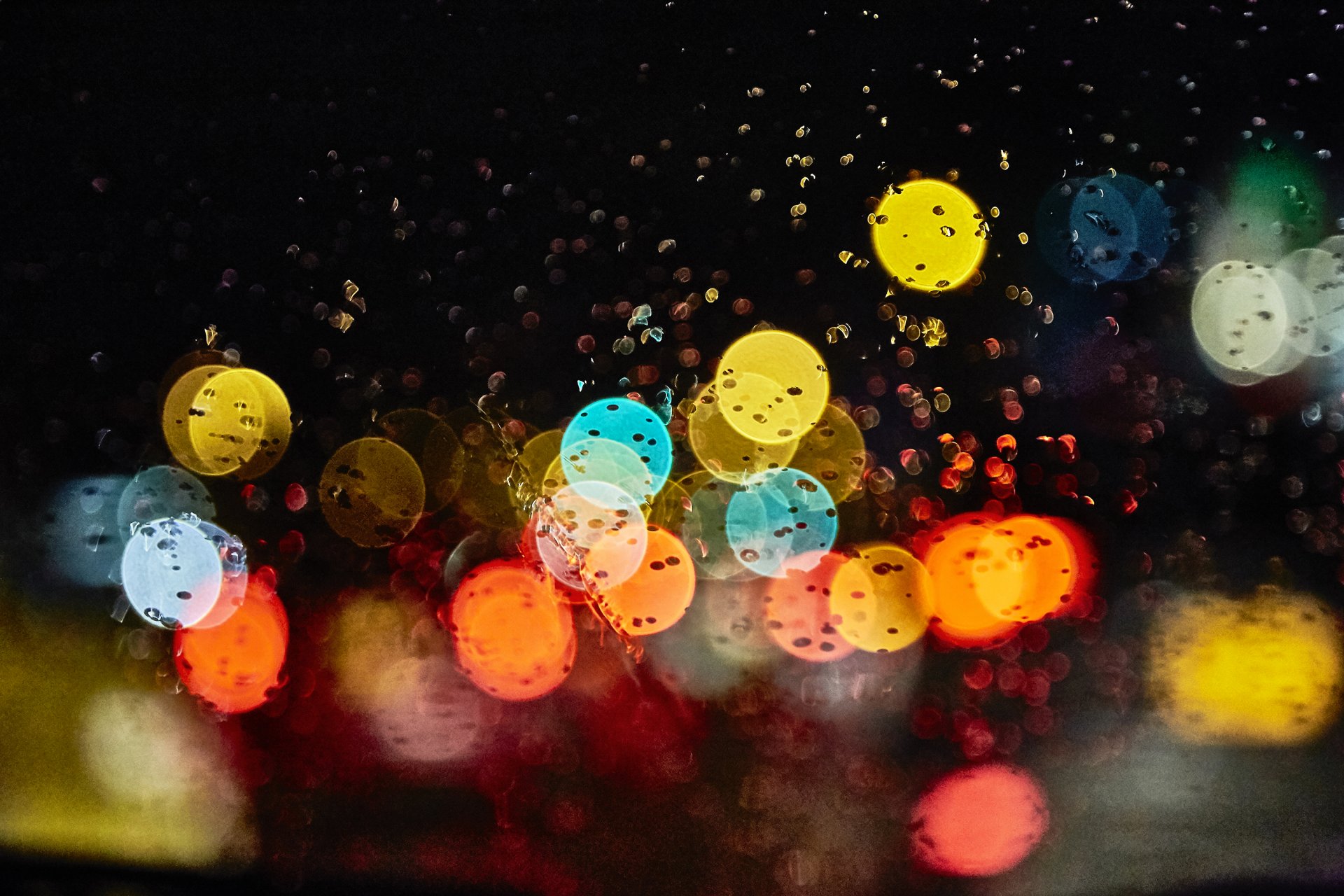 lumières éblouissement gouttes pluie nuit verre bokeh gros plan