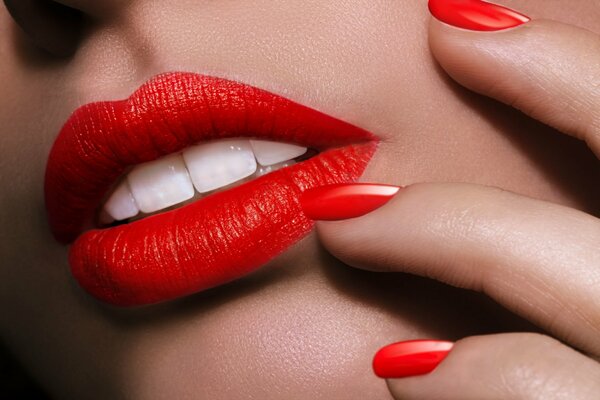 Makrofoto von Gesicht und Händen mit rotem Lippenstift und Lack