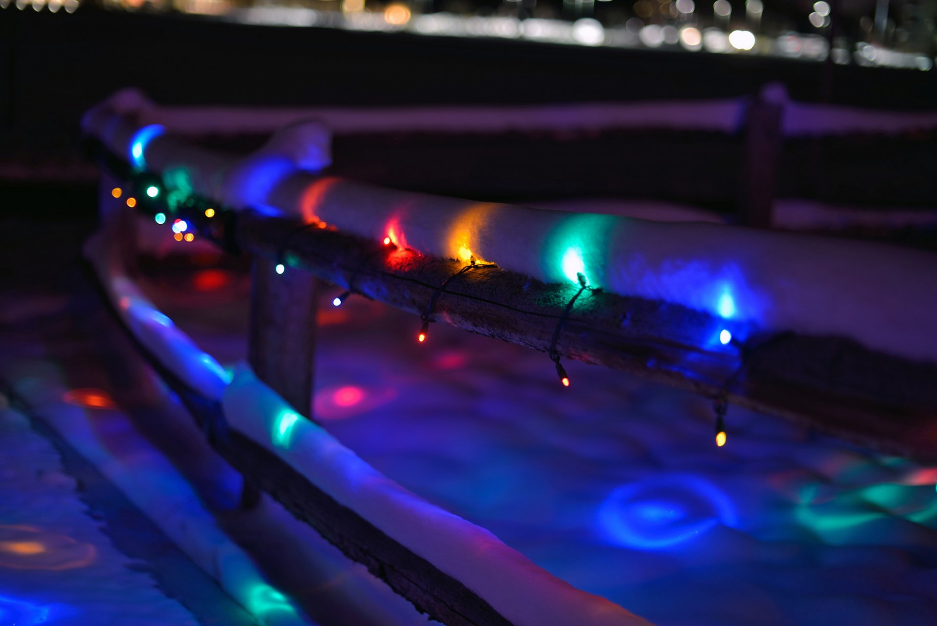 fence wooden fence garland lights lights multicolored winter snow night nature blur