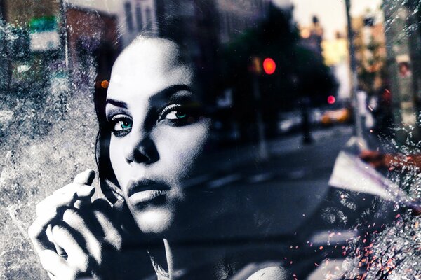 Портрет девушки смотрящей на город через стекло кафе