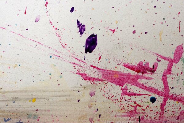 Sur un mur blanc, des éclaboussures de peinture rose