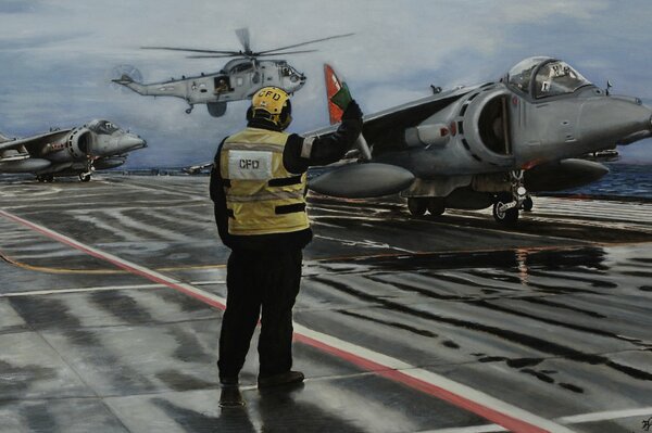 A man in a yellow vest and with a flag. AV-8b attack aircraft in the background