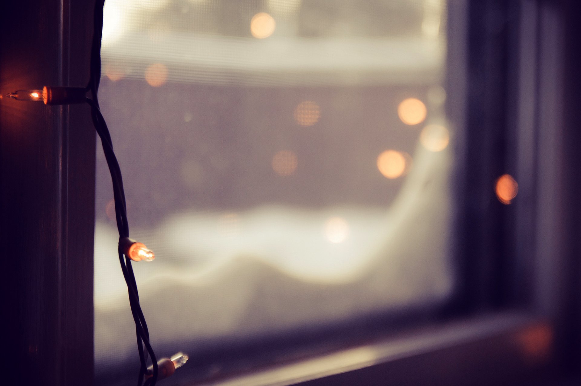 window glass garland lights bokeh blur winter close up