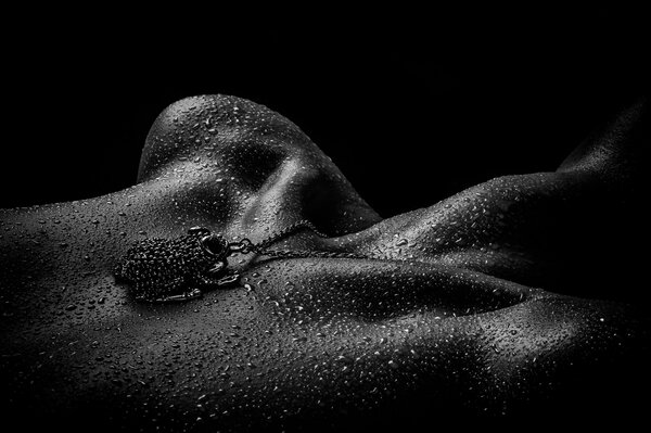 Chica desnuda pechos con aceite colgante en blanco y negro de fondo