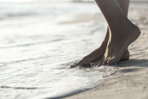Pies descalzos espuma de mar playa de arena