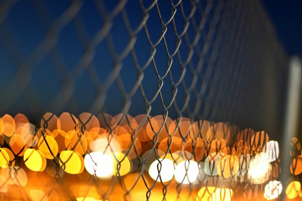 Fence metal mesh with orange lights from lanterns
