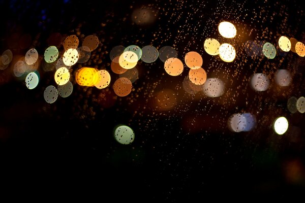 In the evening, when you re sitting in the car, it s raining, dripping from the glass looks multicolored