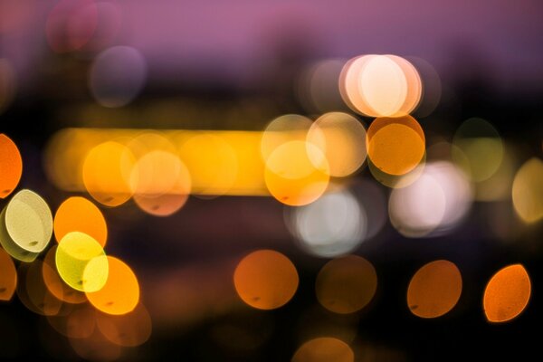 Photo of a blurred city with yellow light. Night city blurry photo