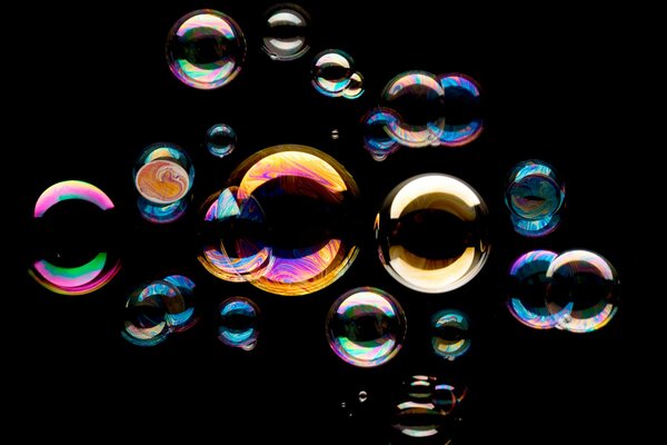 Muchas burbujas de jabón de colores sobre un fondo negro