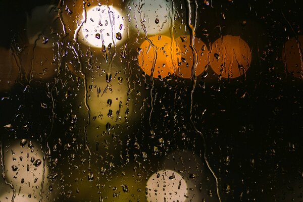 Gocce di pioggia su vetro giallo