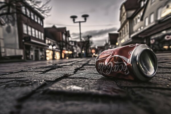 Una lattina vuota di Coca-Cola su uno sfondo di pavimentazione