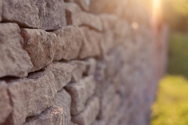 Mur en pierre éclairé par les rayons du soleil