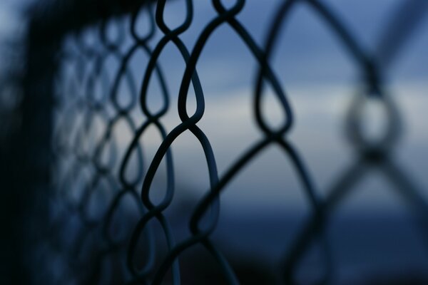 Crepuscolo attraverso le reti di recinzione