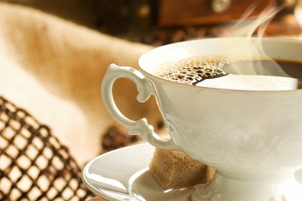 Tazza di caffè con zucchero su piattino