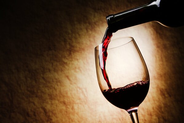 Do szklanki wlewa się czerwone wino
