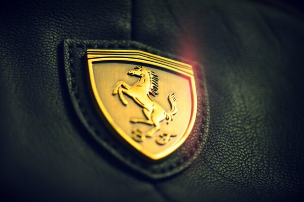 Złote logo Ferrari na skórze