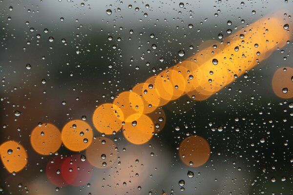 Macro photography of drops on glass and glare of lanterns