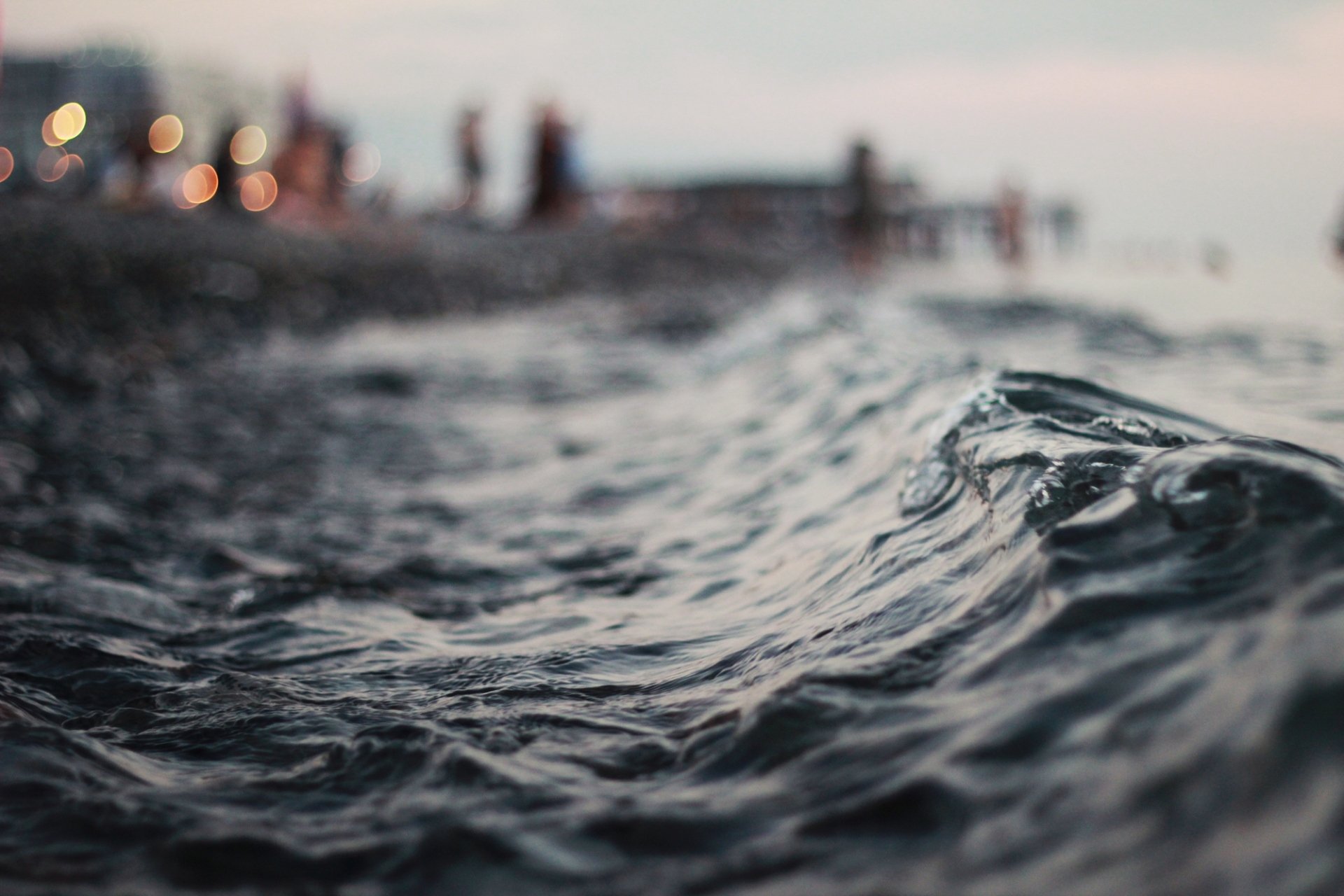 close up water waves night horizon lights bokeh