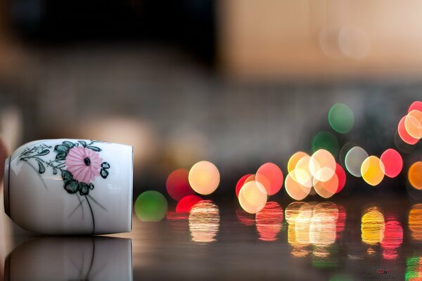 Illusion von Tasse zu Makro mit bunten Lichtbällen