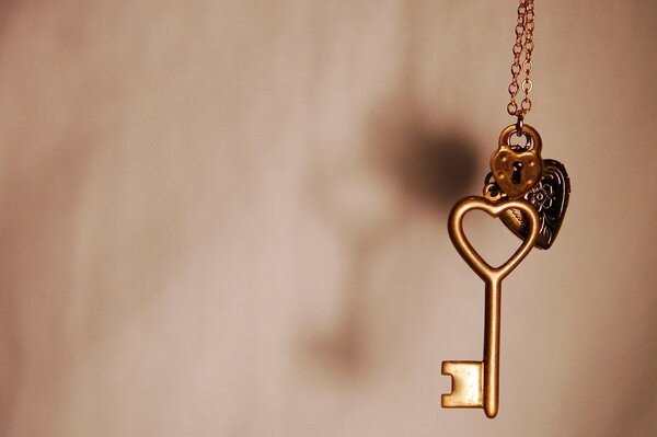 Macro image of a pendant with a key and a heart-shaped lock