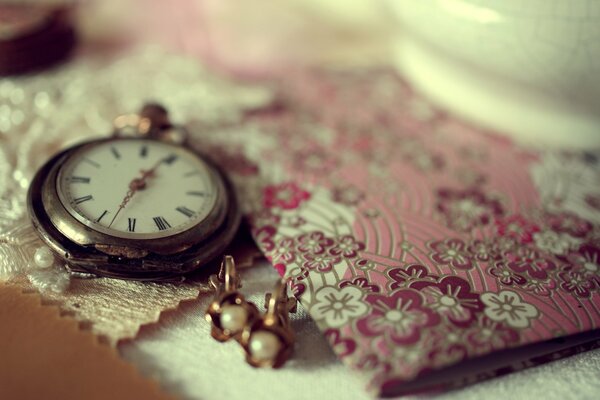 Reloj Vintage y pendientes en la mesa