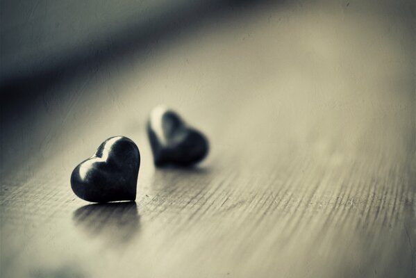 Two black glass hearts on the floor