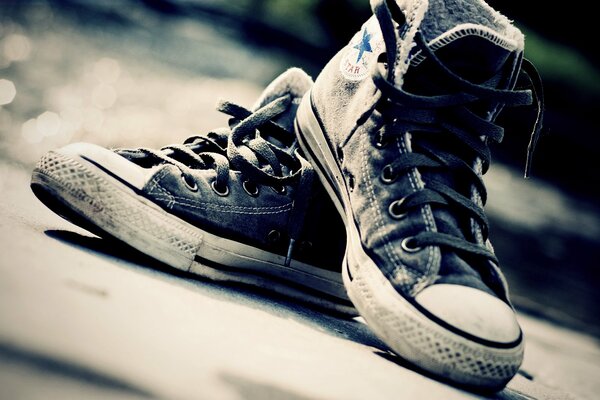 Old sneakers with laces on the asphalt