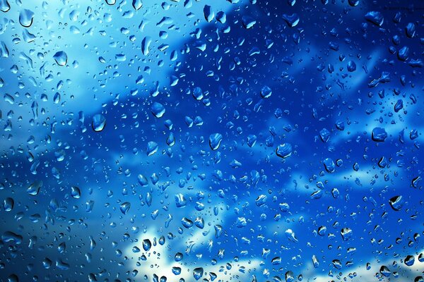 Through the drops on the glass, a view of the sky opens