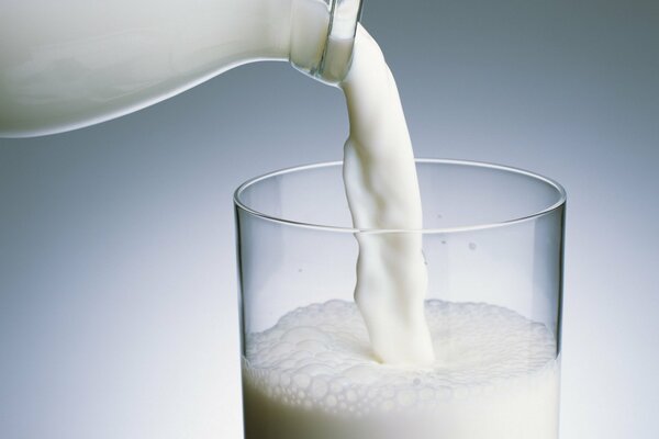 Milk is poured into a transparent glass