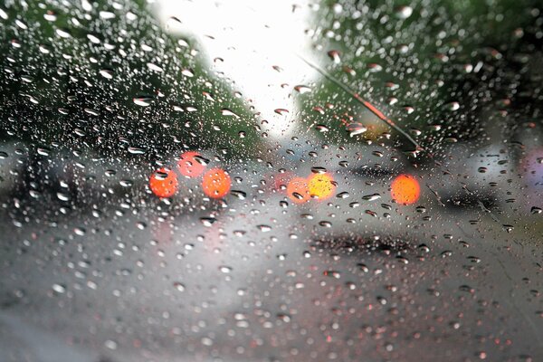 Gotas de macro en el vidrio de la máquina, faros