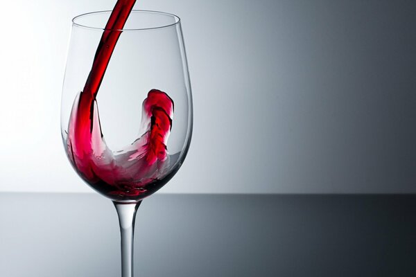 Bicchiere solitario in cui viene versato il vino rosso