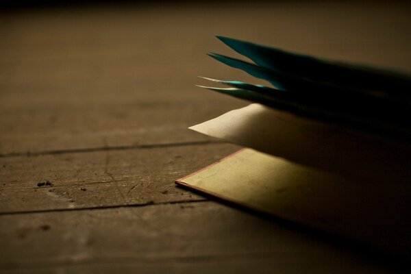 Otwarta książka. Kartki papieru na drewnianej podłodze