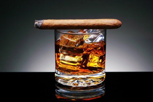 Un cigarro en un vaso de whisky