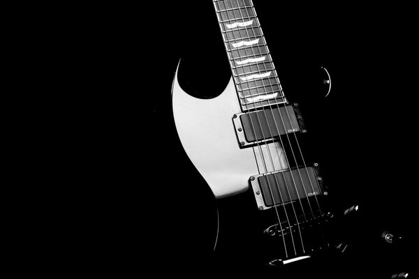 Black guitar with reflections on a black background