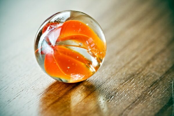 There is a glass ball on a wooden table