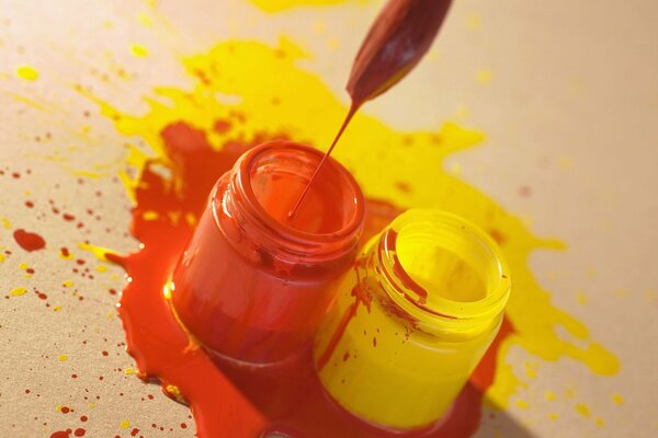 Paints yellow and orange spilled on the table