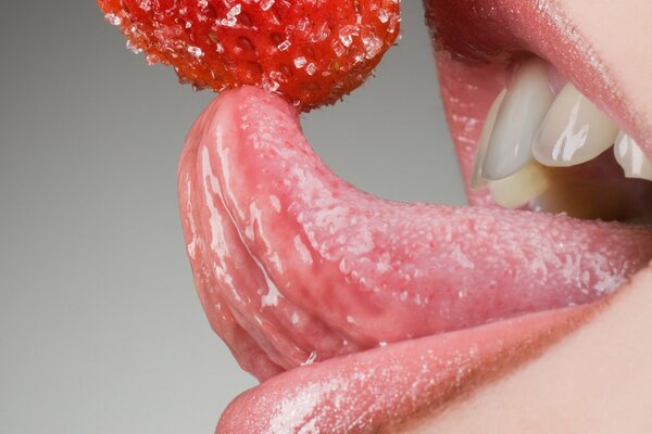 Jugosa fresa de azúcar en la lengua