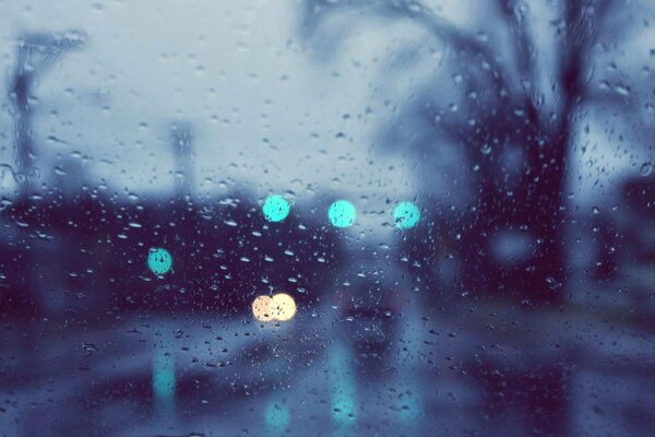 The lights of a rainy street behind the glass