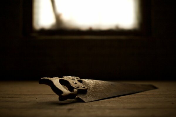 Eine alte Säge auf dem Boden eines verlassenen Hauses