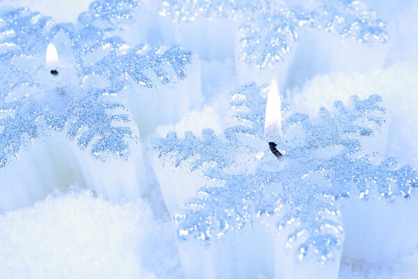 Belles bougies blanches sur la neige blanche