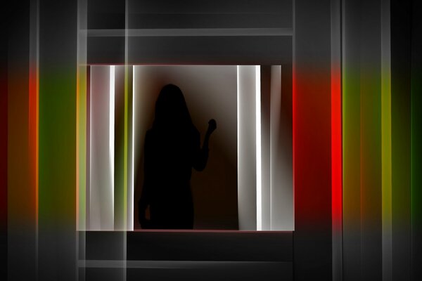 Silhouette of a girl on a dark background among bright lines